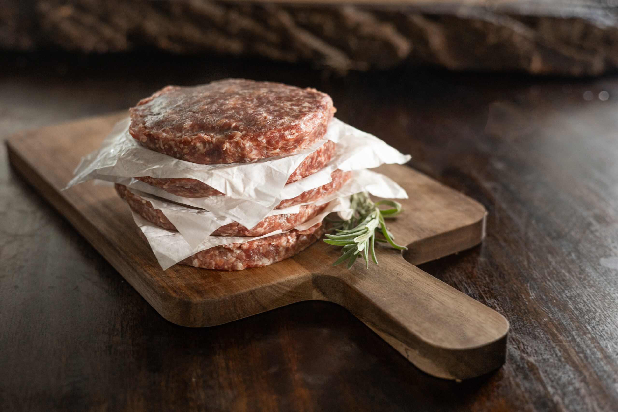Fresh farm eggs in a carton featuring various colors, including brown, white, and cream, resting on a rustic wooden surface. Ideal for cooking and baking.
